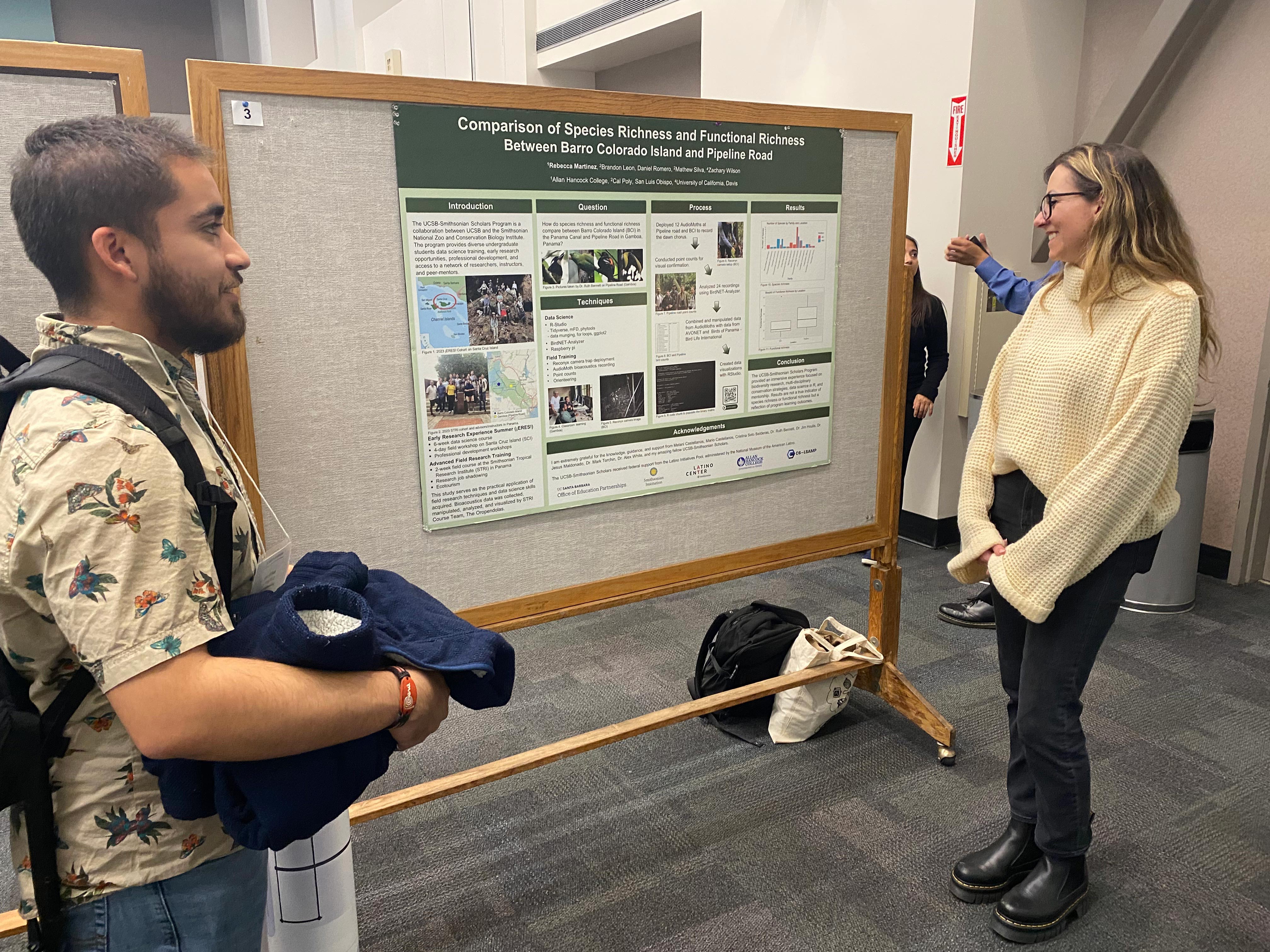 Photo of two people reviewing a poster on a bulletin board