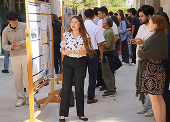 Person in white blouse and black slacks presenting a bulletin board