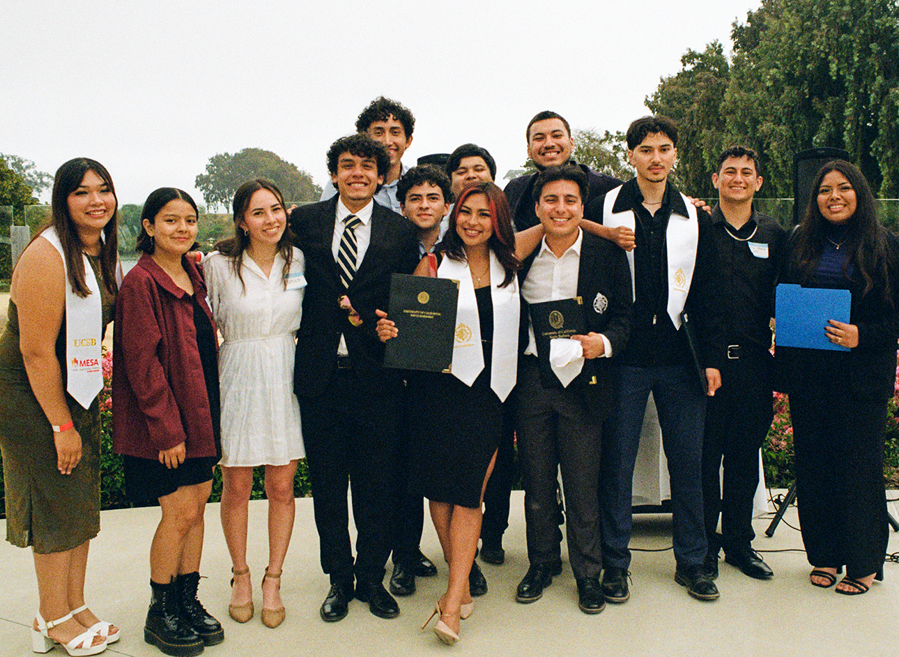 photo of thirteen people posing for a graduation picture